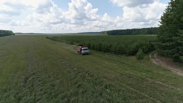 Aerial view of A truck is driving across the field and is approaching the harvesters 34