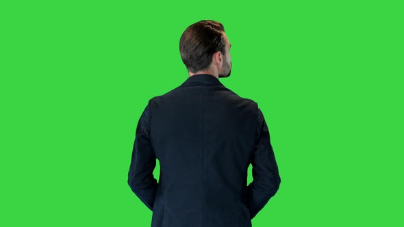 Confident Businessman Standing with Hands on Hips Looking Around on a Green Screen Chroma Key