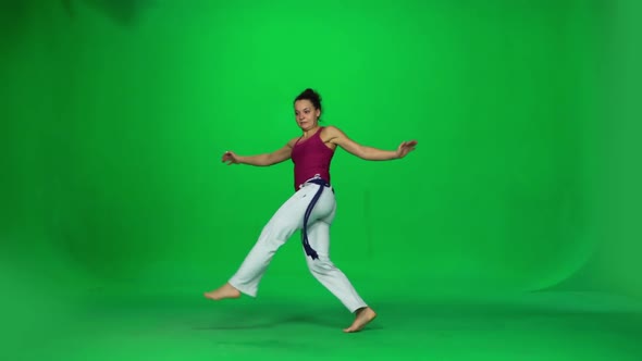 Brunette Female Practicing Capoeira on Green Screen. Slow Motion.