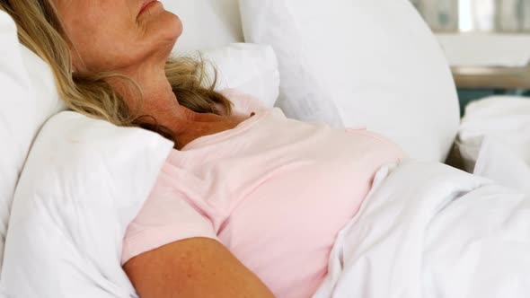 Senior woman sleeping on bed in bed room