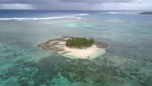 Aerial backwards tracking pedestal up shot of Guyam Island, Siargao, the Philippines