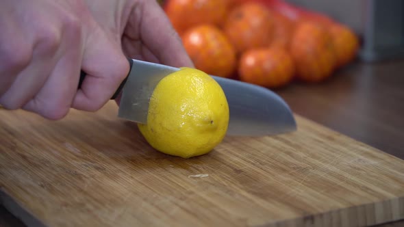 Cutting lemon, two pieces fall down rolling in slow motion