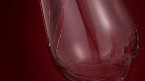 Pouring Red Wine in Super Slow Motion on Red Background