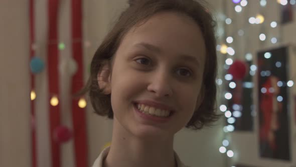 Teenage Girl Looking At Reflection In Mirror Smiling at Herself