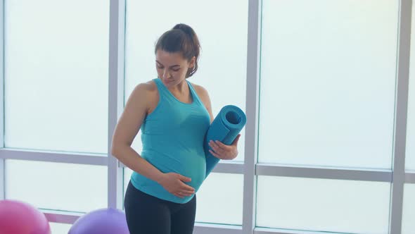 Closeup of a Pregnant Woman's Belly with a Sports Mat