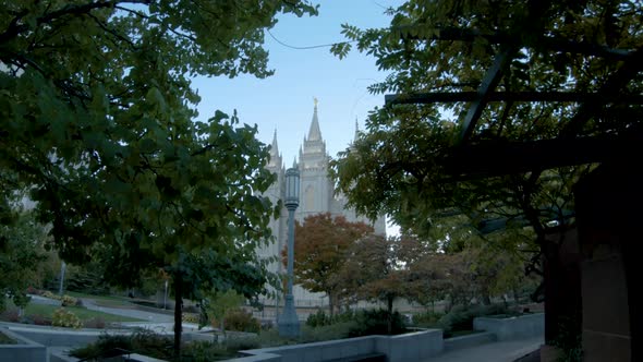 Stepping through the autumn trees to reveal the Slat Lake City Temple in the early morning