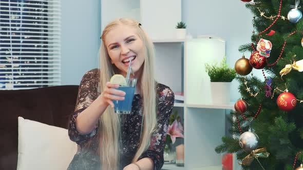 Nice Girl Is Wishing "Happy New Year" with a Glass of Drink