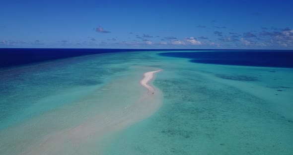 Daytime aerial copy space shot of a white sand paradise beach and aqua blue water background in 4K