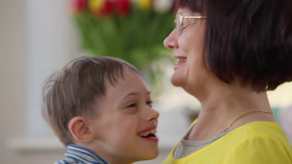 Closeup Positive Mother Kissing Autistic Son Smiling Talking