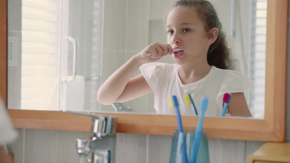 Portrait Happy Cute Young Teenage Girl Brushing Teeth in Bathroom and Smiling