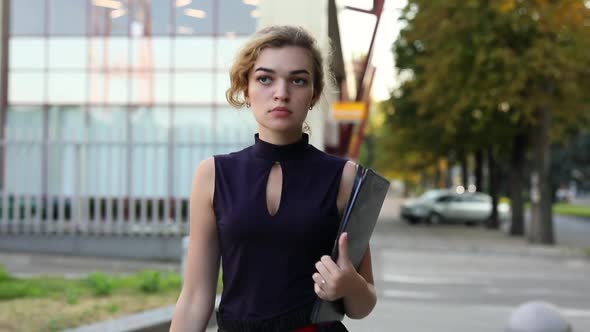 Confident Businesswoman Holding Folder Going From Office