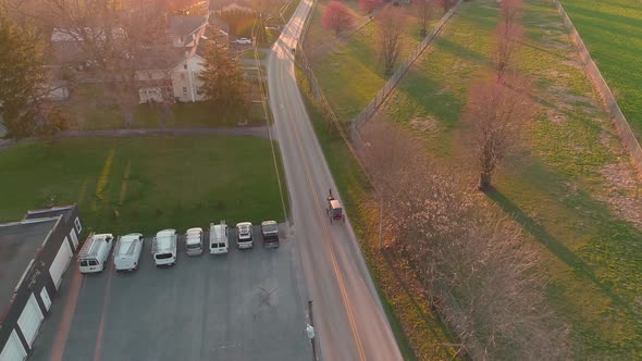 Aerial view of following a horse and buggy in late afternoon