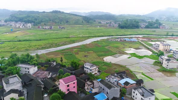 Aerial View of Rural Village Surrounded By Green Terraced Rice Field Farms in South of China