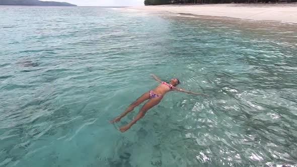 Happy Woman Swimming in the Turquoise Clean Ocean Water Enjoying Summer Spa Vacation to Tropics