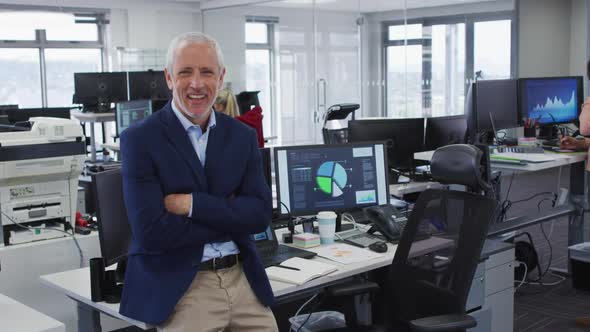Man crossing his arms and smiling while standing in office