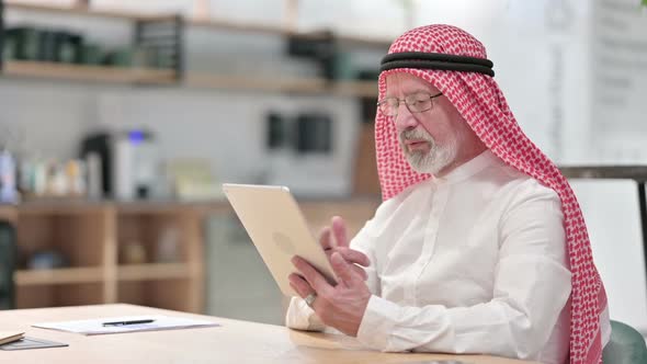 Senior Old Arab Businessman Doing Video Call on Tablet in Caf�