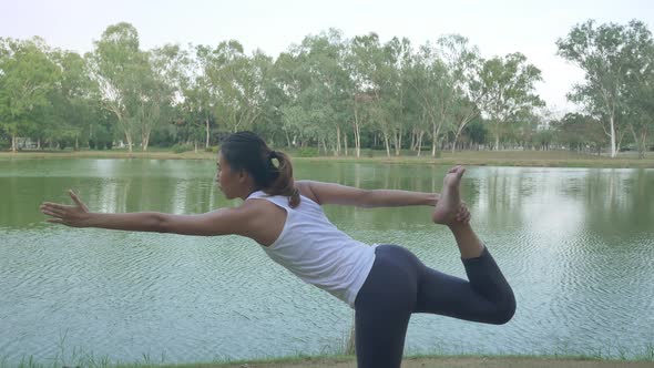 Young asian woman yoga outdoors keep calm and meditates while practicing yoga.
