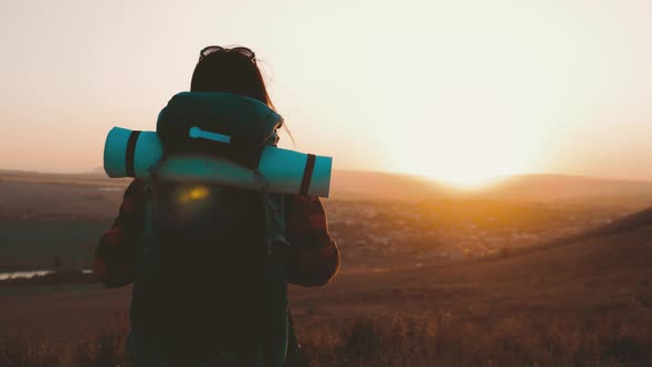 Woman Traveler with Backpack Hiking in Mountains. Silhouette Hiker Walking in the Mountains, Freedom