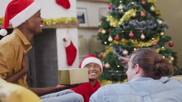 Happy diverse group of friends sharing with presents at christmas time