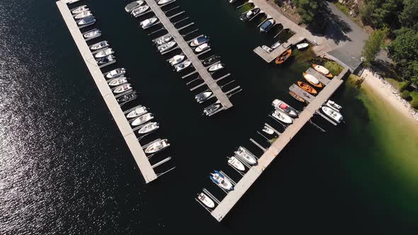 Boats moored in harbour during summer, aerial pull-away reveal