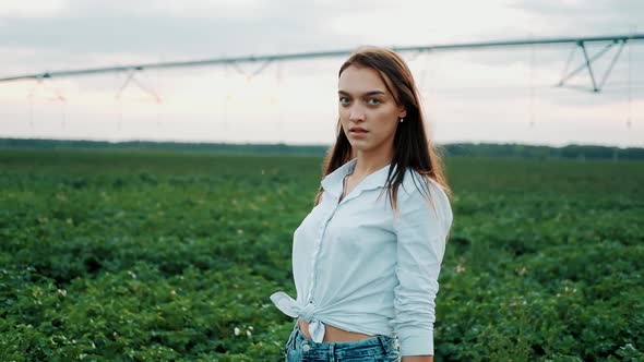 Close Up of Young Farmer Girl in a Shorts Walks Across the Field in Suset Light. Modern Farming