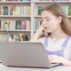 Tired Teen Girl Working on Assignment on Her Laptop at the Library - VideoHive Item for Sale