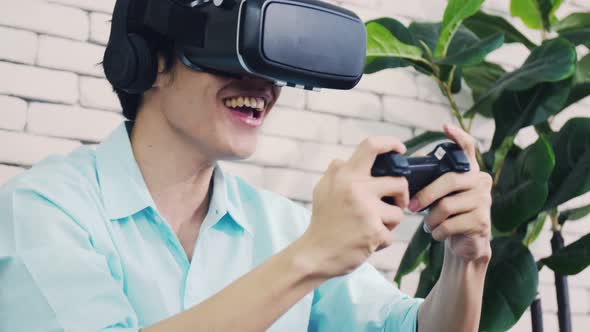Excited handsome man wearing virtual reality glasses playing the game.