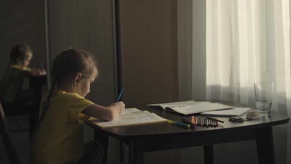 Little preschool girl doing homework at home