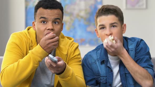 Two Sloppy Teenage Boys Watching Movie on Tv, Eating Popcorn, Home Entertainment