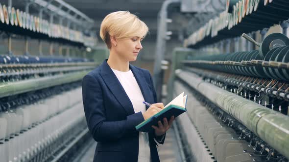 A Woman in a Business Suit is Taking Notes on the Sewing Equipment