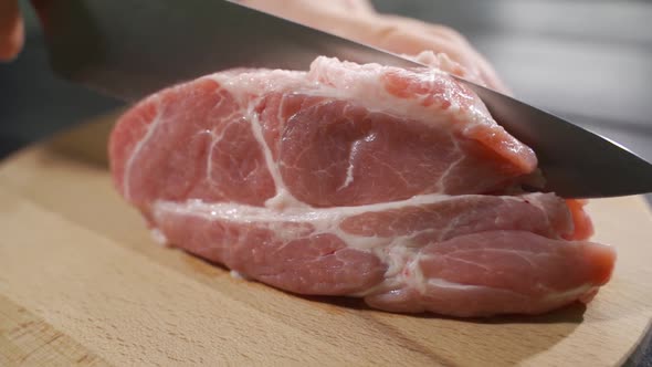 Raw Beef Steak Cut on a Wooden Board, Slow Motion