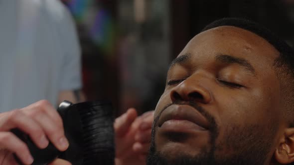 Barber Dusting an African American Guy's Forehead Before Shaving