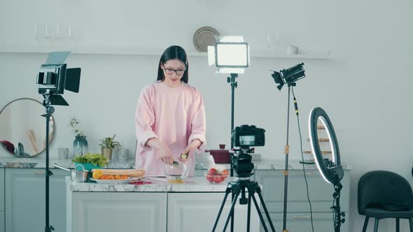 Young Lady is Smiling While Cooking for a Vlog