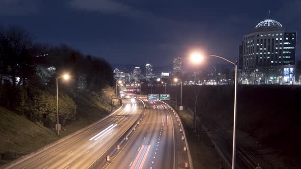 Timelapse of traffic light trails on i84 freeway with Portland Downtown City Skyline at night