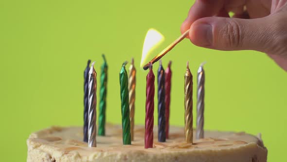 Close Up Hands of Woman Lighting Candles on Birthday Cake