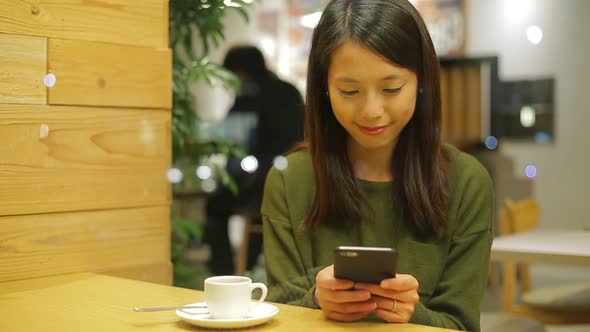 Woman use of smartphone at indoor cafe