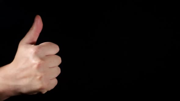 Male hand showing direction gesture on black background.