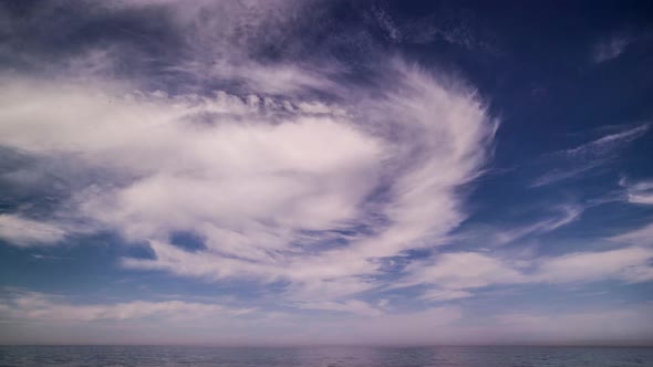 Cinemagraph of clouds swirling at a seashore.