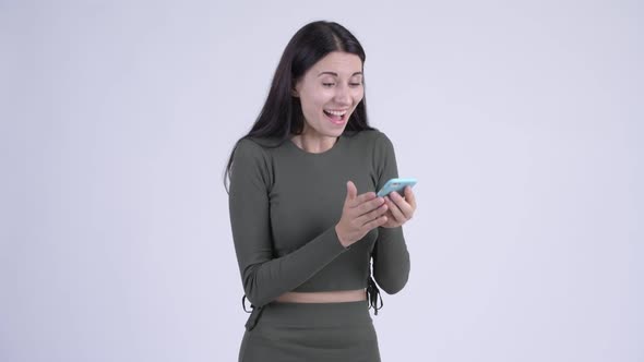 Happy Young Beautiful Woman Using Phone and Looking Surprised