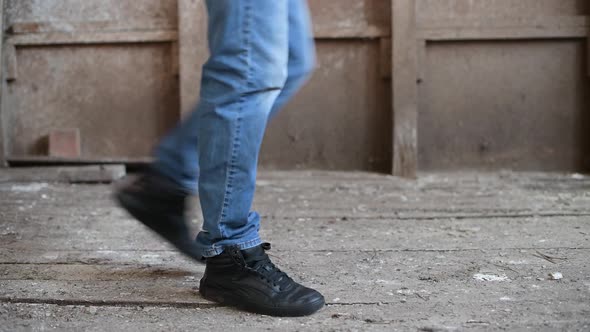 teenager walks along a decrepit floor, rotten boards bend under his boots