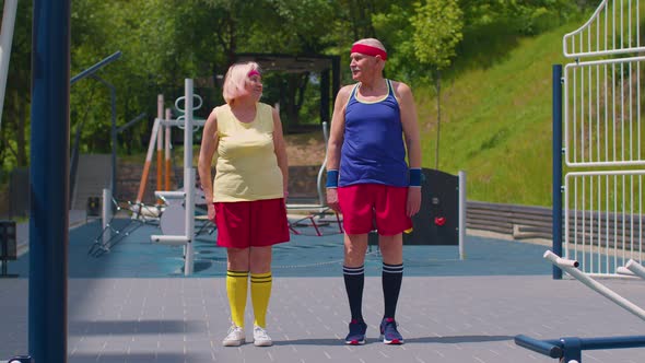 Senior Grandmother and Grandfather Sports Team Doing Squatting Fitness Exercising on Playground