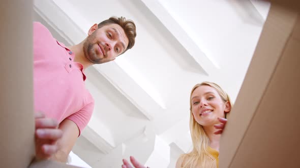 Amazed bearded guy and young woman blonde open brown cardboard box
