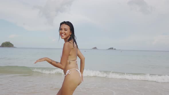 Woman Laughing And Running In Bikini On Beach