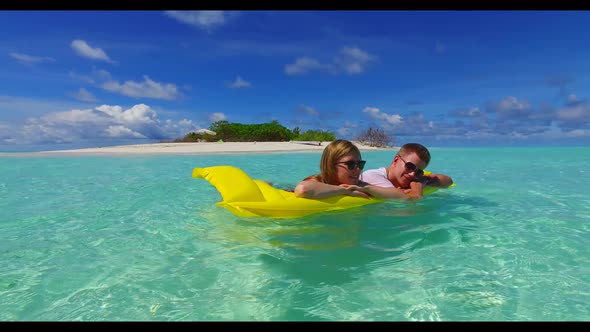 Young couple engaged on beautiful shore beach voyage by transparent sea with white sandy background 