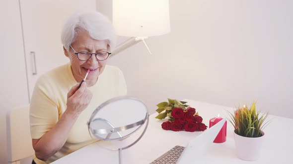 Elderly Woman Applying Lip Glow