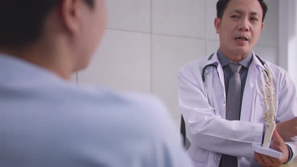 A male doctor is explaining to the patient the cause of the patient's condition.