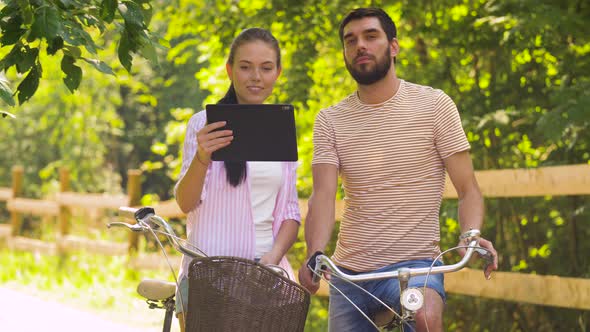 Couple with Tablet Pc and Bicycles at Summer Park