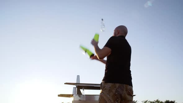 Young Bartender Juggling Making Trick with Three Shakers Outside Slomo Back View