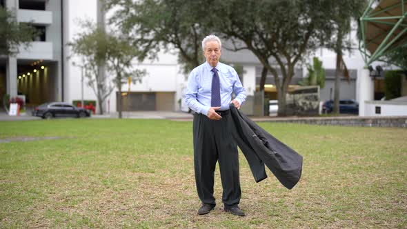 Businessman Removing Jacket In The Park