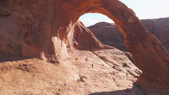 Aerial of a hiker under the Corona Arch near Moab, Utah